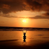 Peaceful meditation silhouette at sunset on a serene beach.